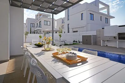 a dining room with a table and chairs on a patio at Villa Elizabeth - Pernera Resort Center in Paralimni
