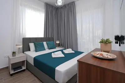 a bedroom with a bed and a table with towels on it at Villa Elizabeth - Pernera Resort Center in Paralimni