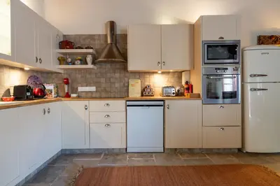 a kitchen with white cabinets and a white refrigerator at Villa Monti Cozy Yard & BBQ Perfect for Families & Friends in Kato Lefkara
