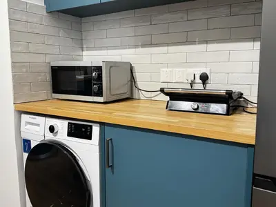 a microwave sitting on a counter next to a washing machine at Cozy Boho 2-BR Retreat in Central Nicosia in Nicosia