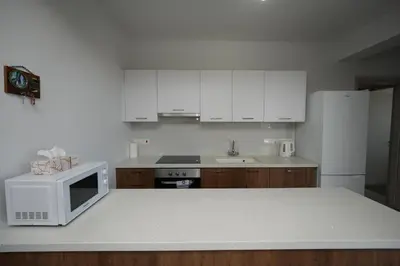 a kitchen with a white microwave and a white refrigerator at Larnaca Salt Lake Gem, Airy 2 BDRM Apartment in Larnaka