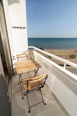 a table and chairs on a balcony with the beach at Stunning Mackenzie Sea Views Beach Flat,1 Bedroom in Larnaka