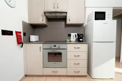 a kitchen with white appliances and a white refrigerator at Stunning Mackenzie Sea Views Beach Flat,1 Bedroom in Larnaka