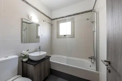 a bathroom with a sink and a tub and a toilet at SunnyVillas 3BR House Private Pool POLY in Protaras