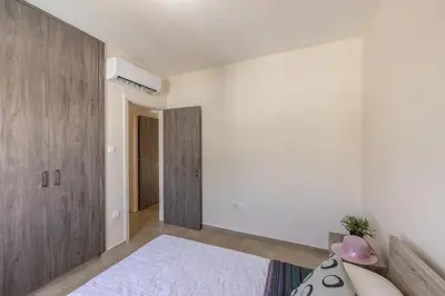 a bedroom with a bed and a wooden cabinet at SunnyVillas 3BR House Private Pool POLY in Protaras