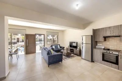 a living room with a blue couch and a kitchen at SunnyVillas 3BR House Private Pool POLY in Protaras