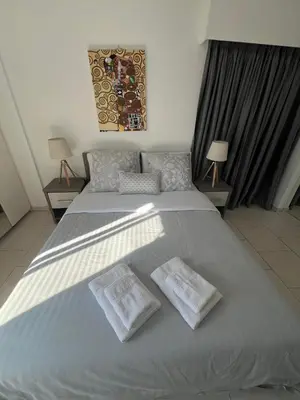 a bedroom with a large bed with two towels on it at City Center Getaway in Nicosia