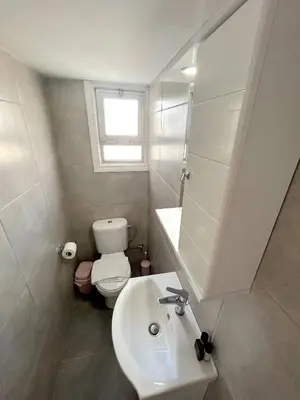a bathroom with a sink and a toilet and a window at City Center Getaway in Nicosia
