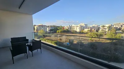 a balcony with a table and chairs and a large window at STAY Engomi Gem 2 in Engomi