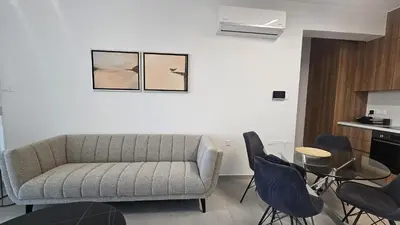 a living room with a couch and a table and chairs at STAY Engomi Gem 2 in Engomi