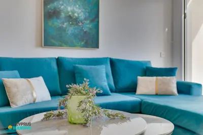 a blue couch with a table in a living room at Lordos Deluxe 2bd Duplex with pool and Seaview in Larnaka