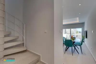 a dining room with a table and green chairs at Lordos Deluxe 2bd Duplex with pool and Seaview in Larnaka