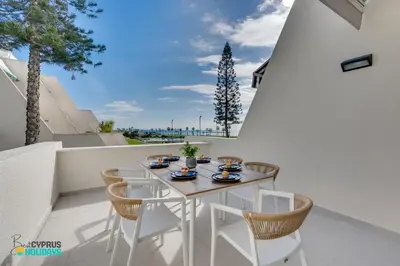 a white table and chairs on a balcony at Lordos Deluxe 2bd Duplex with pool and Seaview in Larnaka