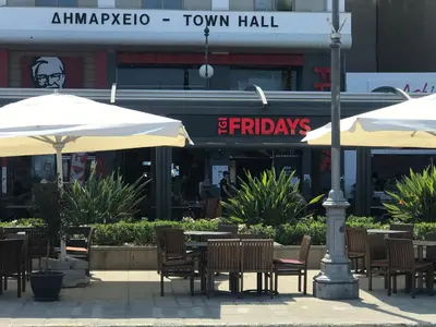 an outdoor patio with tables and chairs and umbrellas at Panoramic Sea View Apartments in Larnaka