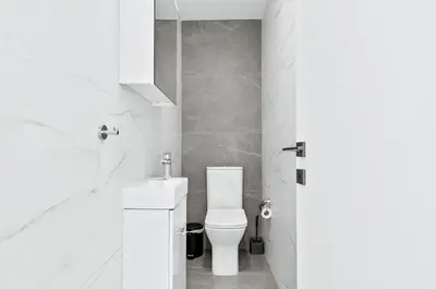 a white bathroom with a toilet and a sink at STYLE Limassol by Ezoria Villas in Limassol