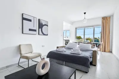 a bedroom with a bed and a living room at STYLE Limassol by Ezoria Villas in Limassol