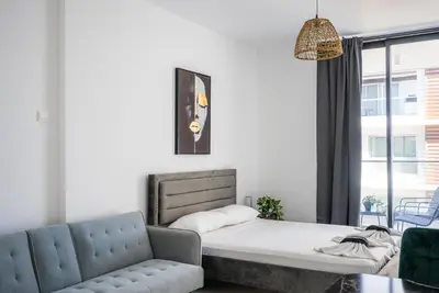 a living room with a bed and a couch at Mackenzie Signature Studio Suite in Larnaca in Larnaka