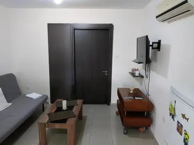 a room with a black door and a couch and a table at 2br-7 Guests-Free Parking-Pool-AirCon in Paralimni