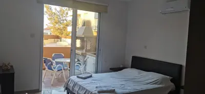 a bedroom with a bed and a balcony with a table and chairs at 2br-7 Guests-Free Parking-Pool-AirCon in Paralimni