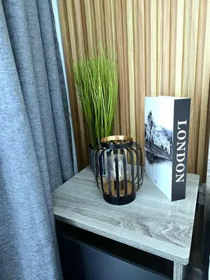 a table with a vase and a book and a plant at Marble Coast Studio Apartment in Larnaka