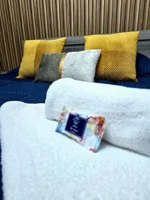 two beds with pillows with a book on them at Marble Coast Studio Apartment in Larnaka