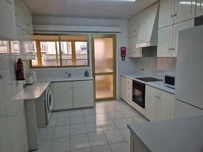 a large kitchen with white cabinets and appliances at Urban Nest Central Nicosia - Spacious 2BR Apartment in Nicosia