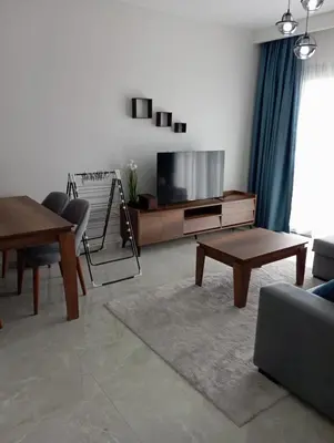 a living room with a tv and a table at Rıversıdelıfe Iskele M 147 in Aglantzia