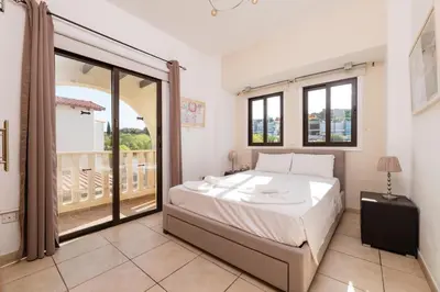 a bedroom with a bed and a balcony at Sunnyside Family Villa in Protaras