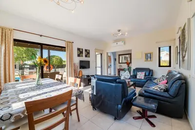a living room with a table and chairs and a couch at Sunnyside Family Villa in Protaras