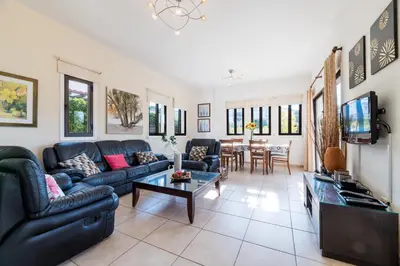 a living room with a couch and a table at Sunnyside Family Villa in Protaras