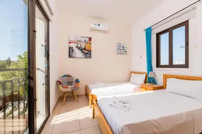a bedroom with two beds and a balcony at Sunnyside Family Villa in Protaras