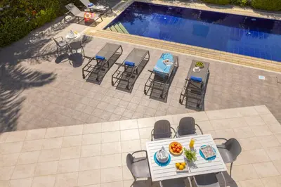 an overhead view of a table and chairs next to a pool at Pantaros Luxury Villas with pool in Paralimni