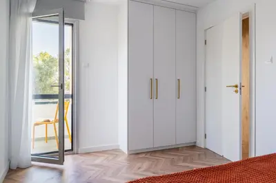 a bedroom with white cabinets and a sliding door at Modern Luxury 2BR|Park View & Balcony in Nicosia