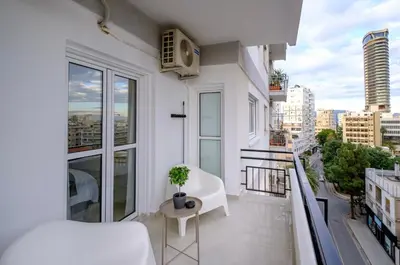 a white apartment balcony with a plant on it at Mnasiadou Suite 16 in Nicosia