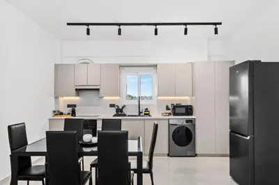 a kitchen with a table and a black refrigerator at Mnasiadou Suite 16 in Nicosia