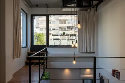 a staircase in a room with a large window at Cozy Loft with Balcony in Central Limassol in Limassol