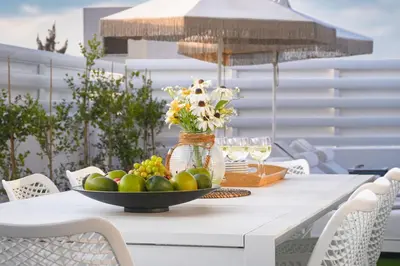 a table with a bowl of fruit and wine glasses at Villa Elsa - Luxury Villa in Pernera in Paralimni