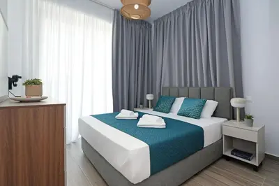 a bedroom with a large bed with a blue blanket at Villa Elsa - Luxury Villa in Pernera in Paralimni