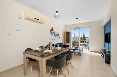 a dining room and living room with a table and chairs at Sunny 2Br Family Apartment - Mythical Sands Resort in Protaras