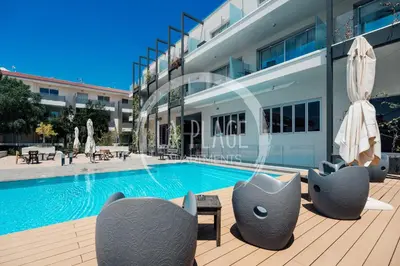 a swimming pool in front of a building at Sunny 2Br Family Apartment - Mythical Sands Resort in Protaras