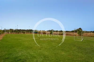 a soccer field with a net in the grass at Sunny 2Br Family Apartment - Mythical Sands Resort in Protaras