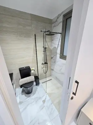 a bathroom with a toilet and a glass shower at Mediterranean Sunrise Villa Protaras in Paralimni