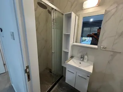 a bathroom with a sink and a shower and a mirror at Veray Homes in Nicosia