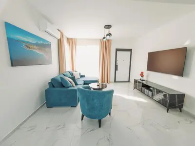 a living room with a blue couch and a tv at Chic Blue Apartment with Terrace in Paralimni