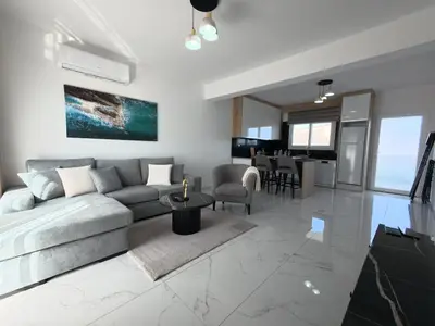 a living room with a couch and a table at Chic Sunset Apartment with Terrace in Protaras