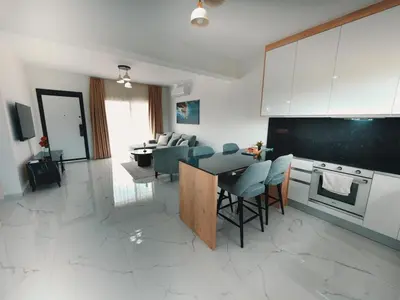a kitchen and living room with a table and chairs at Chic Sunset Apartment with Terrace in Protaras