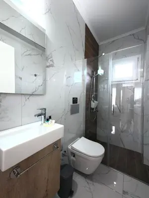 a bathroom with a toilet and a sink and a shower at Chic Sunset Apartment with Terrace in Protaras