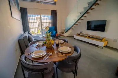 a dining room with a wooden table and chairs at Stylish Loft - 50m from Beach in Paralimni