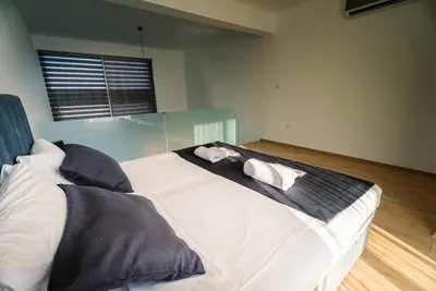 a bedroom with a large white bed with pillows at Stylish Loft - 50m from Beach in Paralimni
