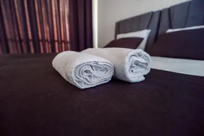 a pair of towels sitting on top of a bed at Stylish Loft - 50m from Beach in Paralimni